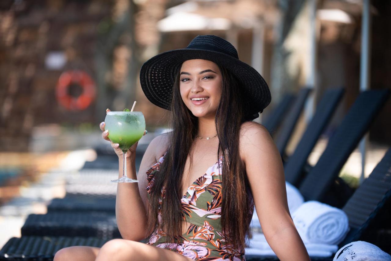 The Capital Zimbali Hotel Ballito Exterior foto A woman wearing a sun hat