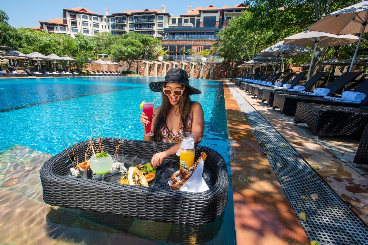 The Capital Zimbali Hotel Ballito Exterior foto A woman at a poolside lounge